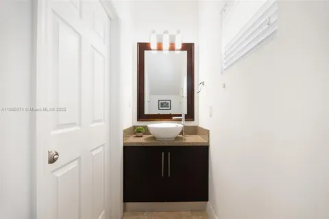 a bathroom with a granite countertop sink and mirror