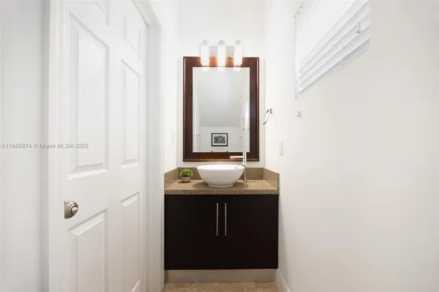 a bathroom with a granite countertop sink and mirror