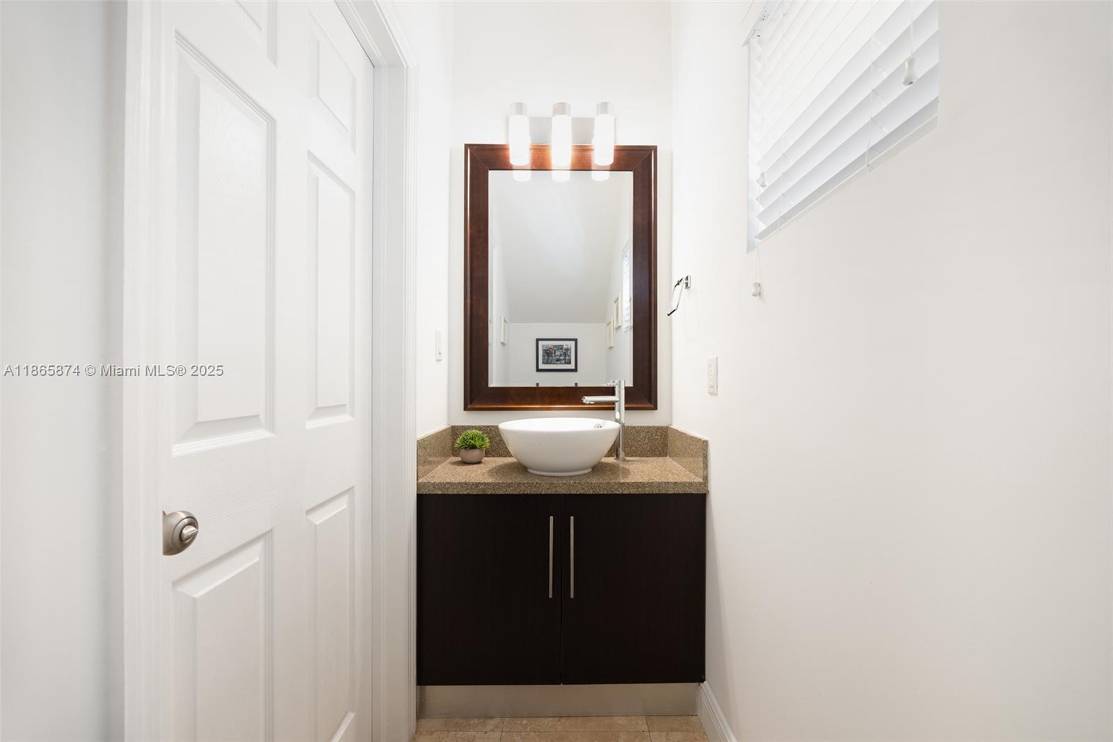 3109 Hibiscus Street, Unit 3109 Coconut Grove, FL 33133 - Photo 20 of 25 a bathroom with a granite countertop sink and mirror