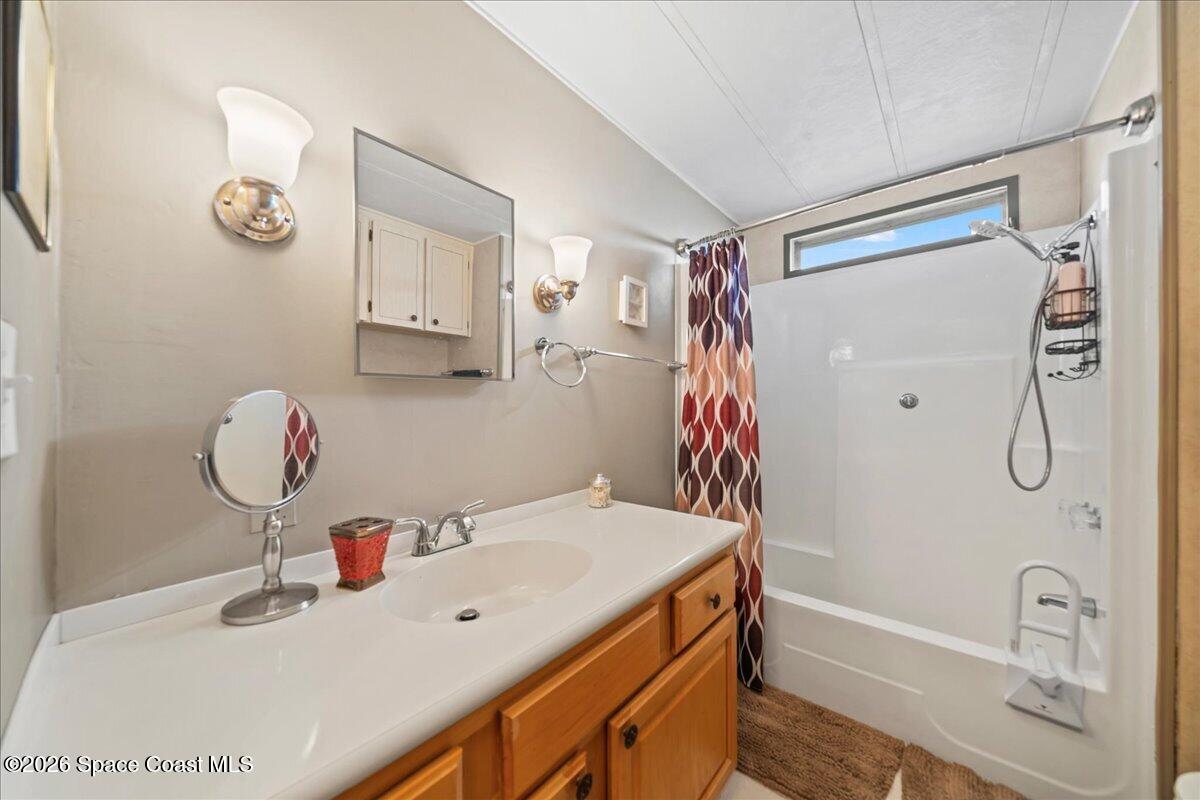 1740 Seagrape Street Northeast Palm Bay, FL 32905 - Photo 14 of 33 a bathroom with a sink vanity tub and shower