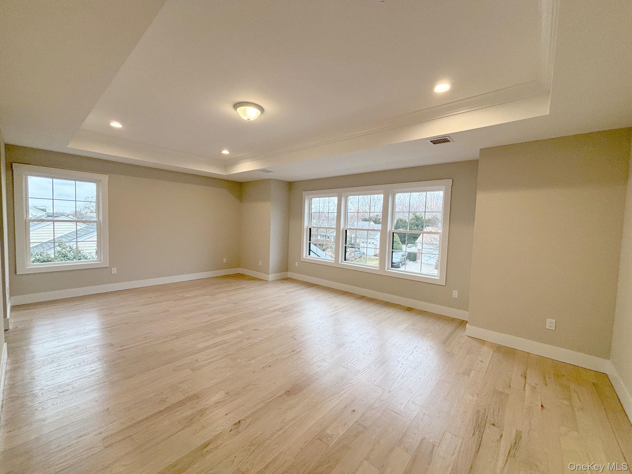 1750 Henry Road Merrick, NY 11566 - Photo 11 of 14 an empty room with wooden floor and windows