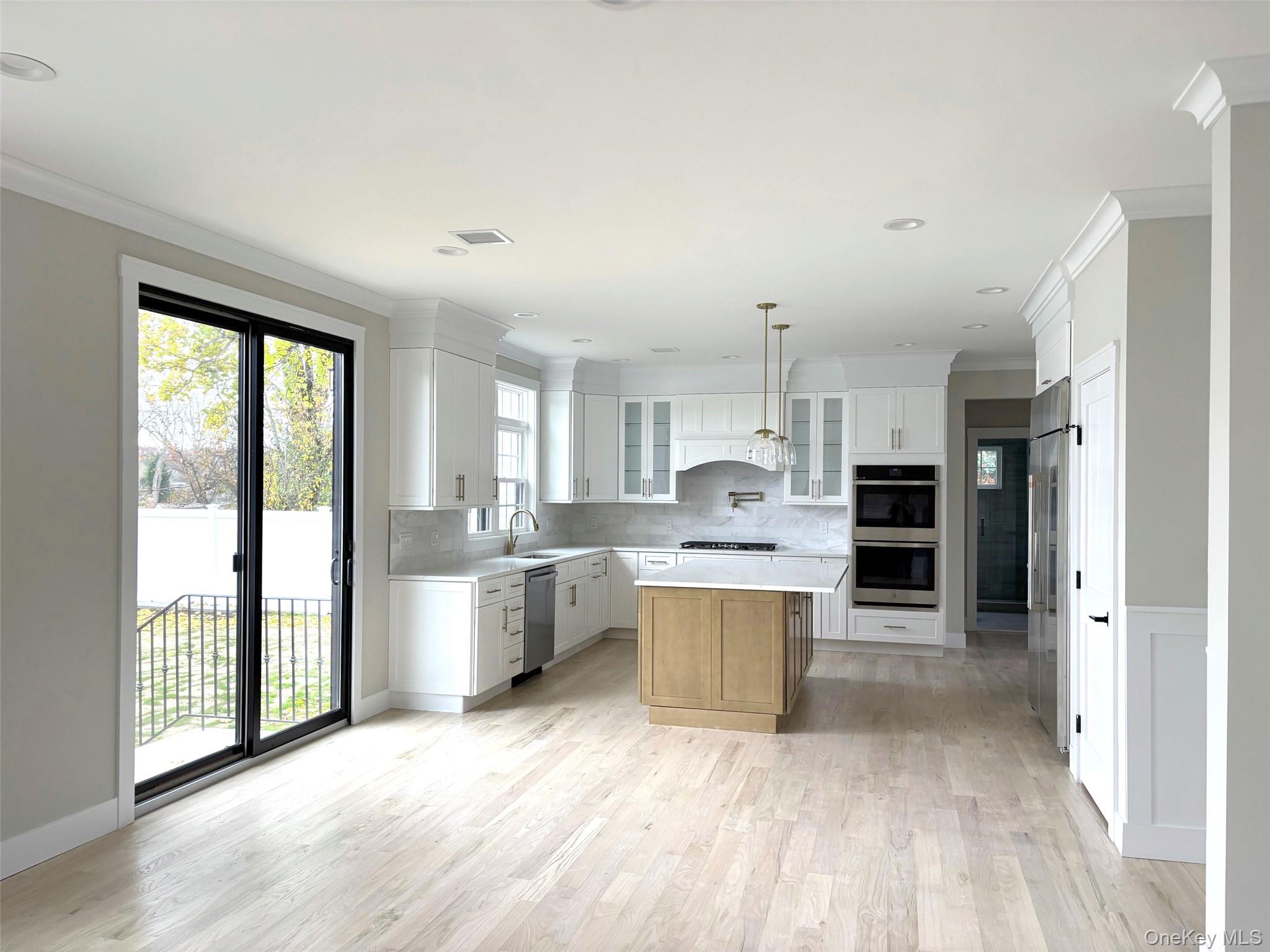 1750 Henry Road Merrick, NY 11566 - Photo 6 of 14 a open kitchen with white cabinets and stainless steel appliances