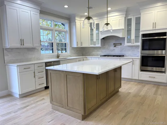 a kitchen with a sink stove top oven and cabinets