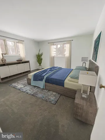 a spacious bedroom with a bed a couch and windows