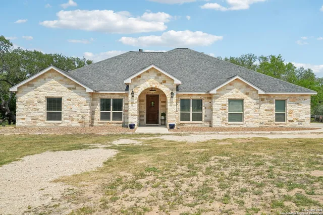 a large kitchen with a large counter top space appliances and a ceiling fan