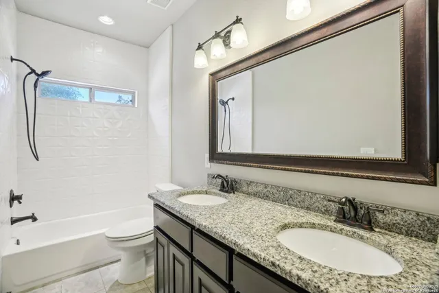 a bathroom with a granite countertop tub sink and mirror
