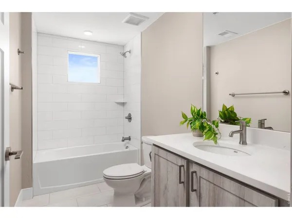 a bathroom with a sink a toilet a tub and a glass door