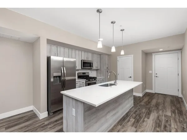 a kitchen with refrigerator cabinets and wooden floor