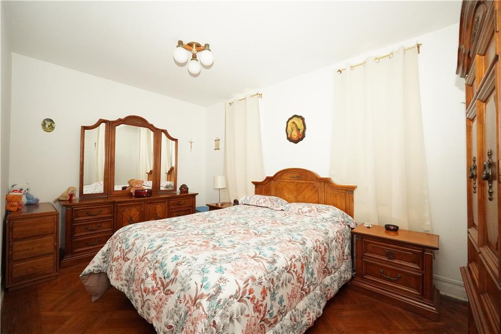 1636 Dahill Road Brooklyn, NY 11223 - Photo 7 of 19 a bedroom with a bed and dresser with mirror