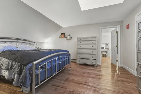 a bedroom with a bed and wooden floor