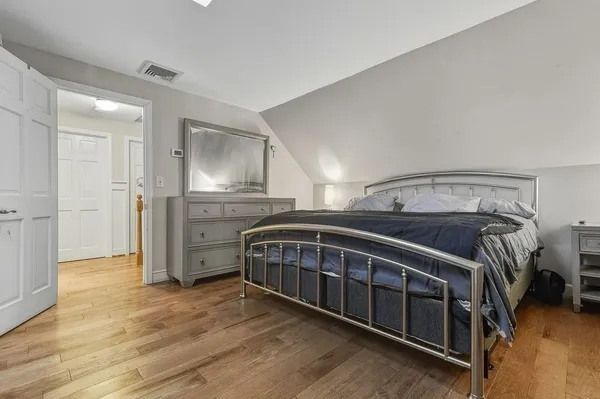 a bedroom with a bed and wooden floor