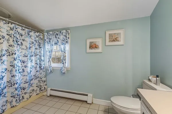 a bathroom with a toilet and a shower curtain