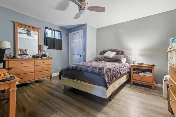 a bedroom with a bed and wooden floor