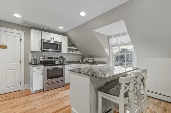 a kitchen with stainless steel appliances granite countertop a stove a sink and a microwave
