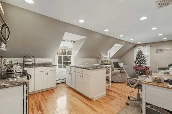 a kitchen with a sink a stove and chairs with wooden floor