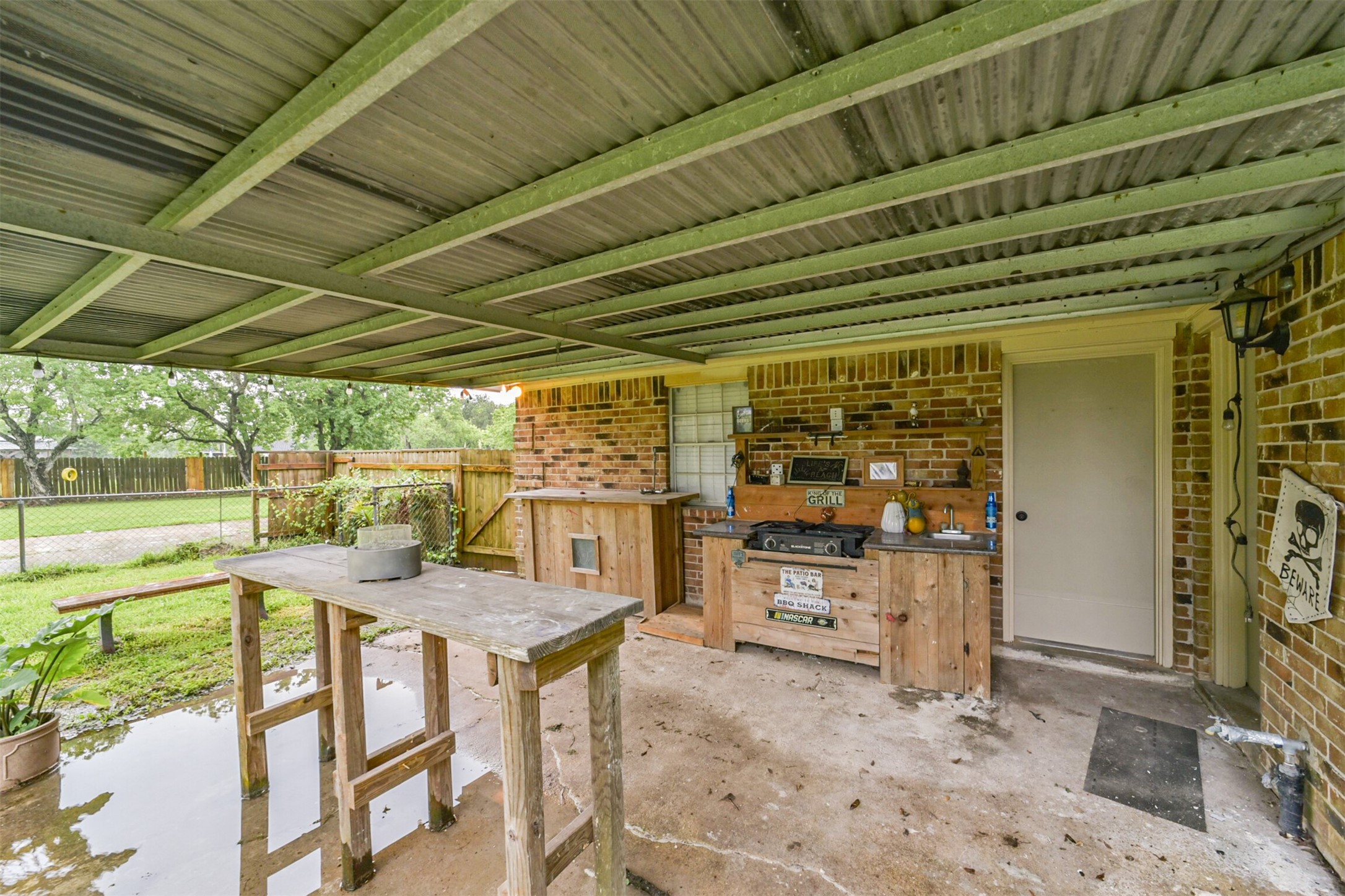 5403 Croix Road Manvel, TX 77578 - Photo 10 of 25 Covered patio featuring an outdoor cooking station and cozy seating area — perfect for entertaining or relaxing year-round.