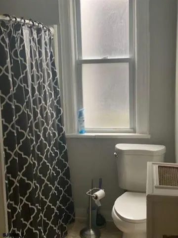 a kitchen with wooden floor and white stainless steel appliances