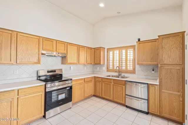 a kitchen with cabinets appliances and a window