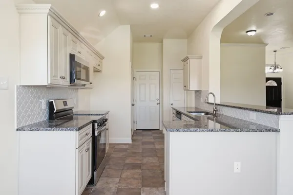 a kitchen with a sink stove and cabinets