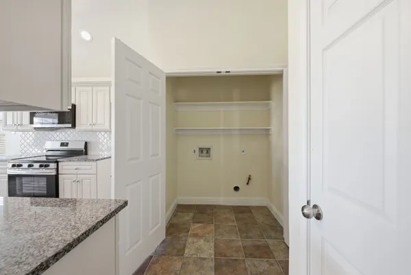 a kitchen with a granite countertop sink and white cabinets
