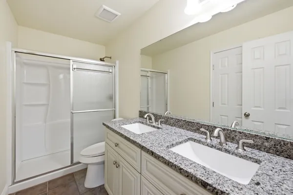 a bathroom with a granite countertop sink toilet and shower