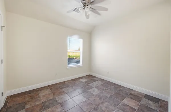 an empty room with a window and a fan