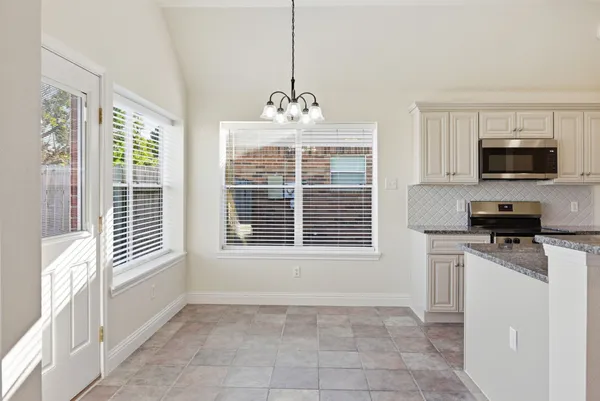 a view of a kitchen with microwave and windows