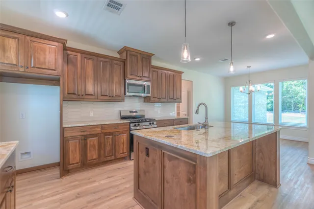a kitchen with granite countertop a stove and a wooden floors