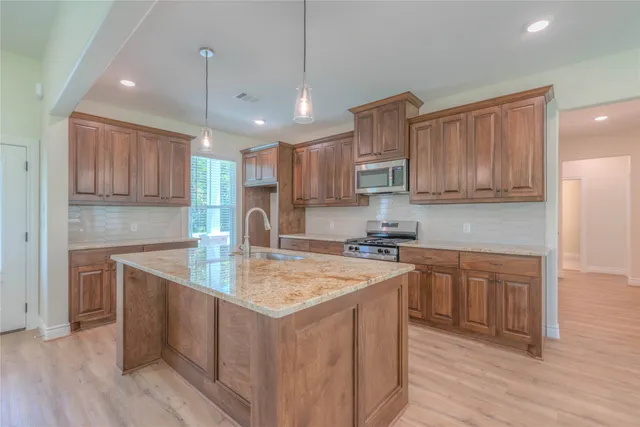 a kitchen with a sink a center island cabinets and a window