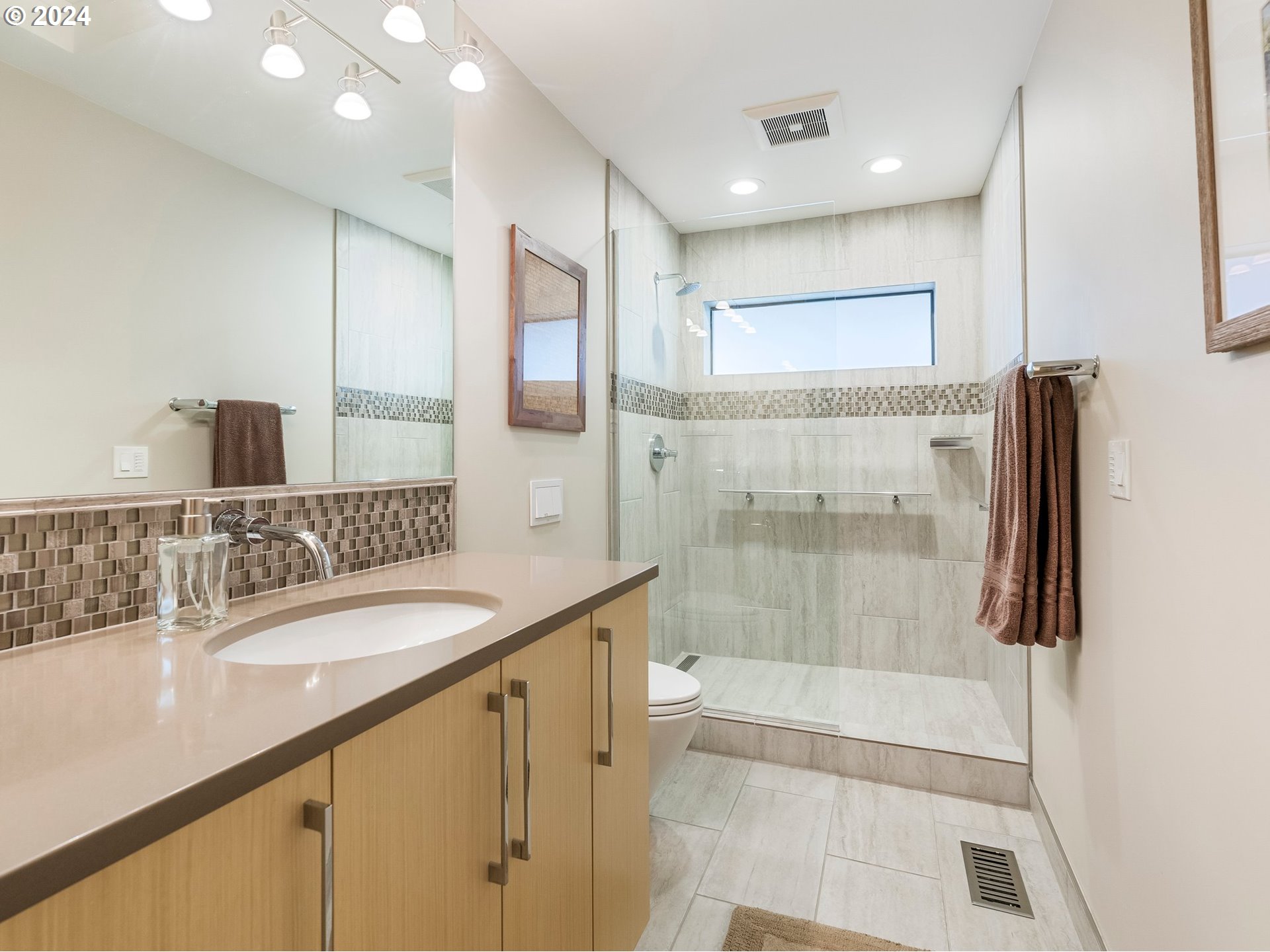 222 Southeast Spokane Street, Unit 3 Portland, OR 97202 - Photo 33 of 47 a bathroom with a granite countertop sink a mirror and a shower