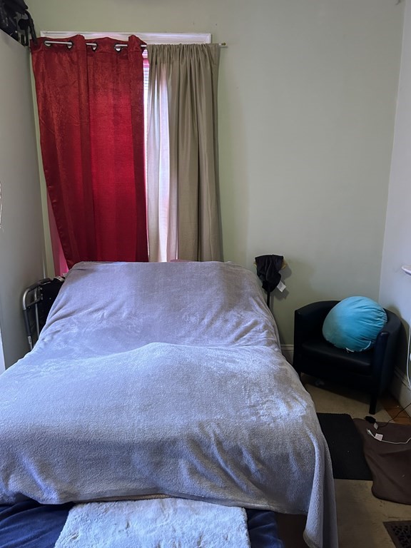 61 Forest Street Boston, MA 02119 - Photo 27 of 36 a bedroom with a bed and a chair