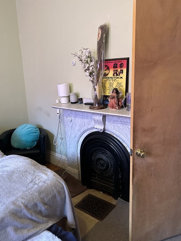 61 Forest Street Boston, MA 02119 - Photo 28 of 36 a bed room with a bed and a fireplace