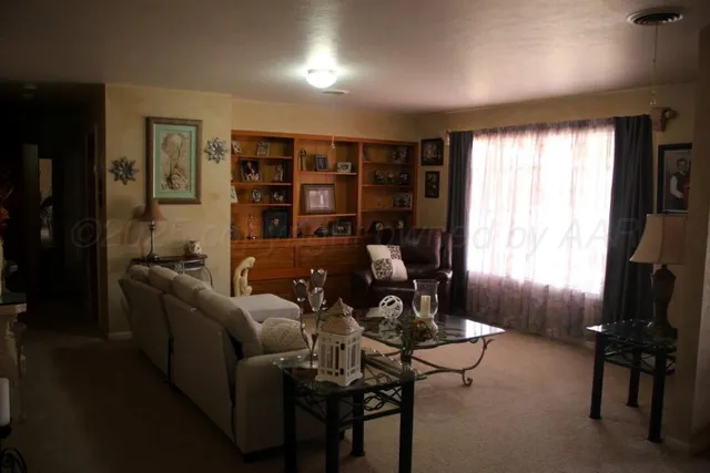 a living room with furniture a window and a flat screen tv