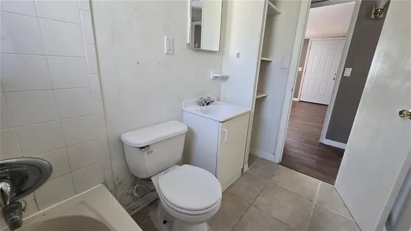 a white toilet sitting next to a small sink and toilet