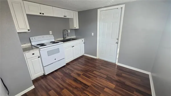 a room with wooden floor and cabinets