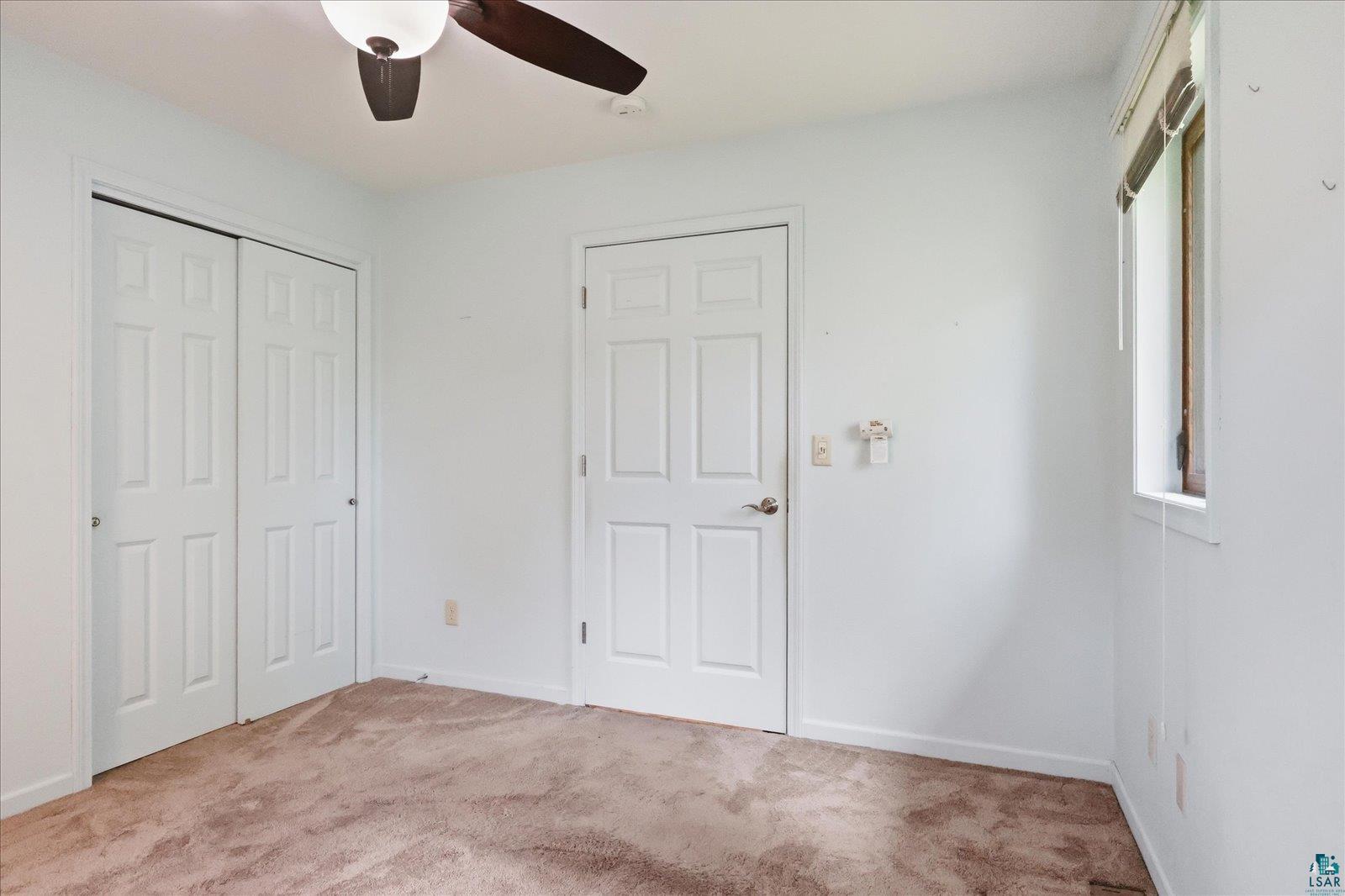 5192 Lavaque Junction Road Hermantown, MN 55811 - Photo 19 of 34 Room featuring textured carpeting, a white multi-panel door, and white bi-fold closet doors
