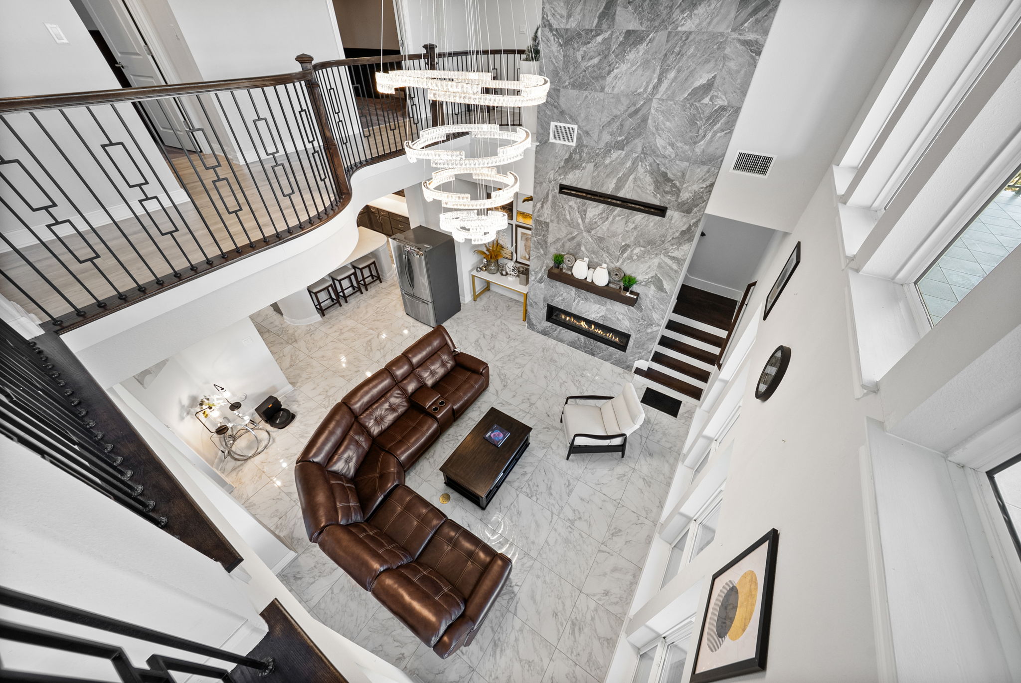 2132 Novara Trail Leander, TX 78641 - Photo 25 of 40 Living area featuring a high ceiling, light marble finish floors, suspended lighting, and a fireplace