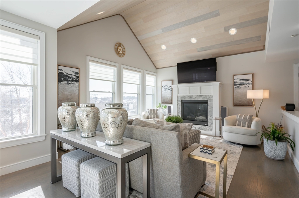 78 Thatcher Road, Unit 6 Gloucester, MA 01930 - Photo 1 of 41 a living room with furniture a fireplace and a floor to ceiling window