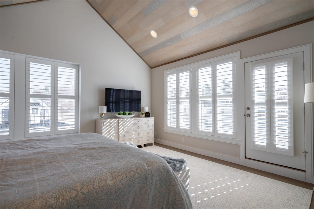 78 Thatcher Road, Unit 6 Gloucester, MA 01930 - Photo 19 of 41 a spacious bedroom with a large bed and a flat tv screen next to a window
