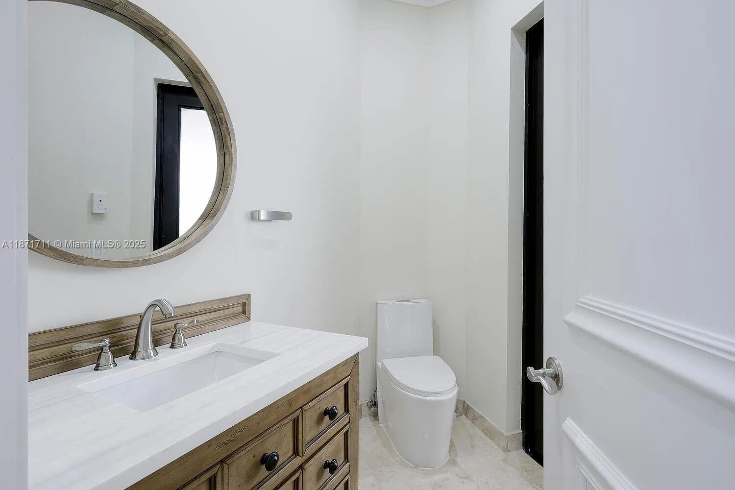 17838 Monte Vista Drive Boca Raton, FL 33496 - Photo 30 of 66 a bathroom with a toilet sink and mirror