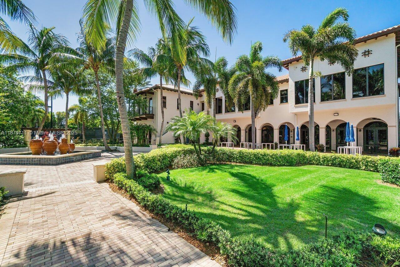 17838 Monte Vista Drive Boca Raton, FL 33496 - Photo 47 of 66 a view of a white house with a yard potted plants and palm trees