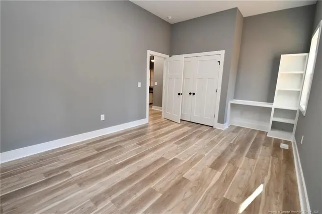 a view of empty room with wooden floor