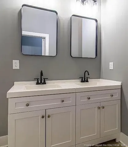 a bathroom with double vanity sinks and two mirror