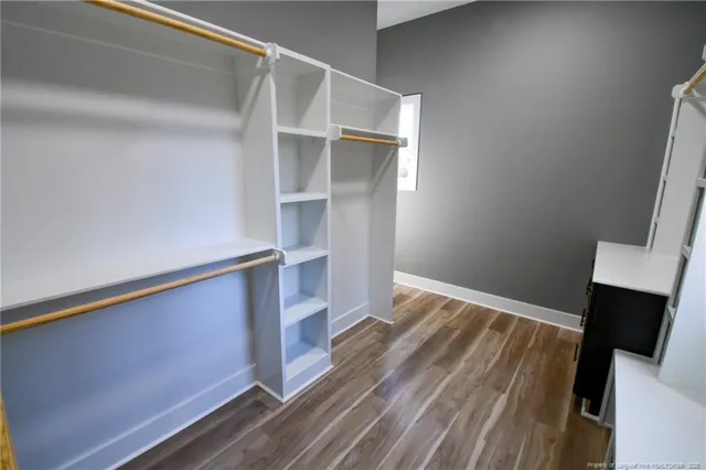 a view of walk in closet with wooden floor