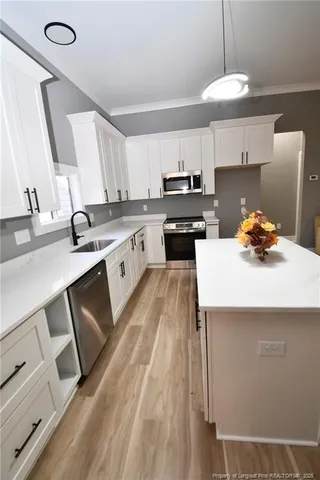 a kitchen with a sink a stove and cabinets