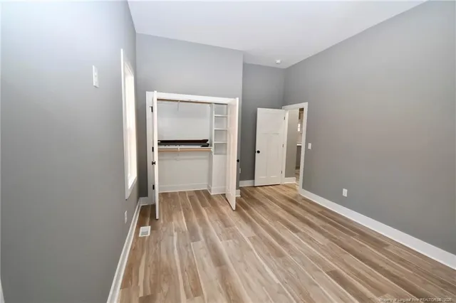a view of empty room with wooden floor