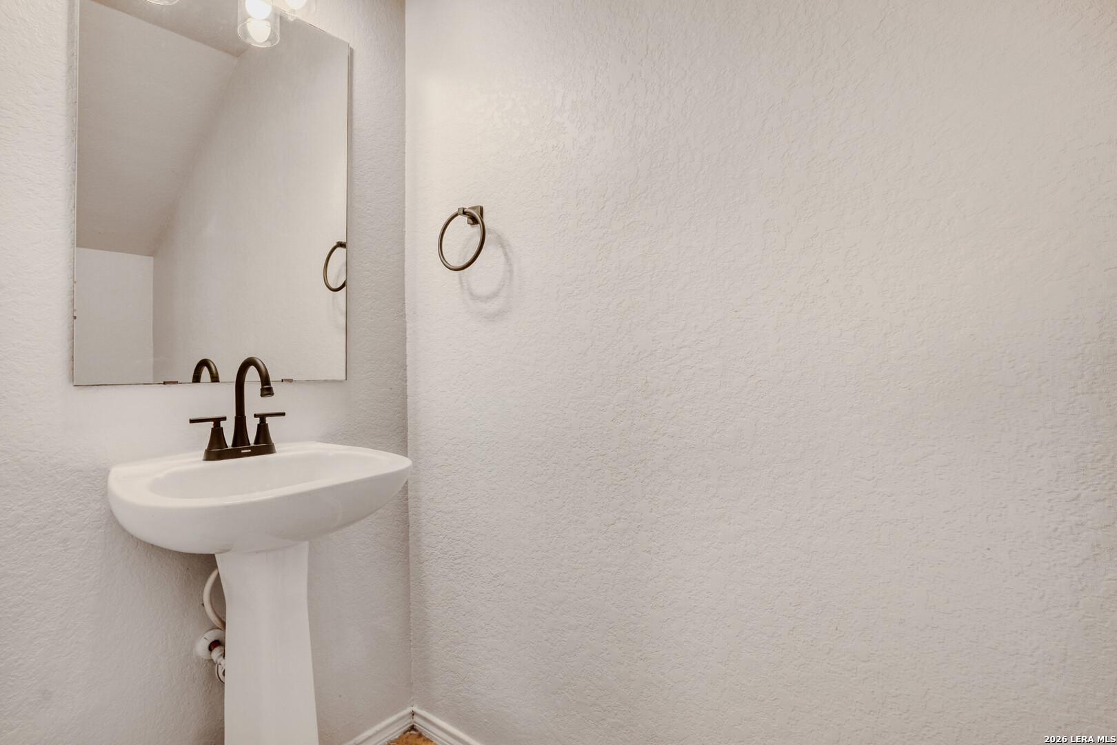 312 Passerina Spur Schertz, TX 78154 - Photo 14 of 26 a bathroom with a sink a mirror and shower