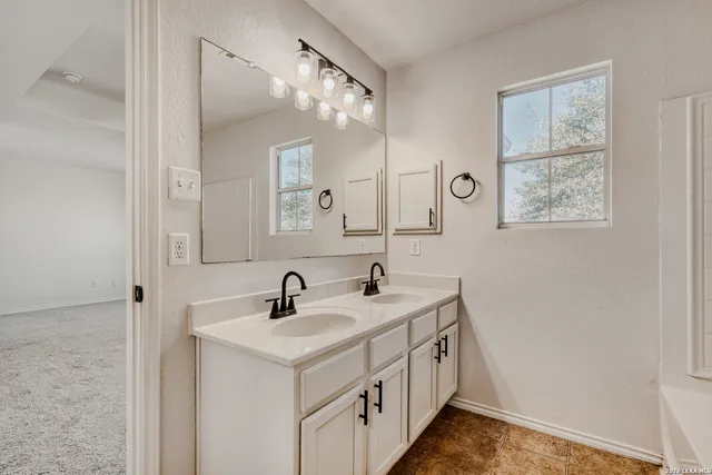 a bathroom with 2 sink and a mirror