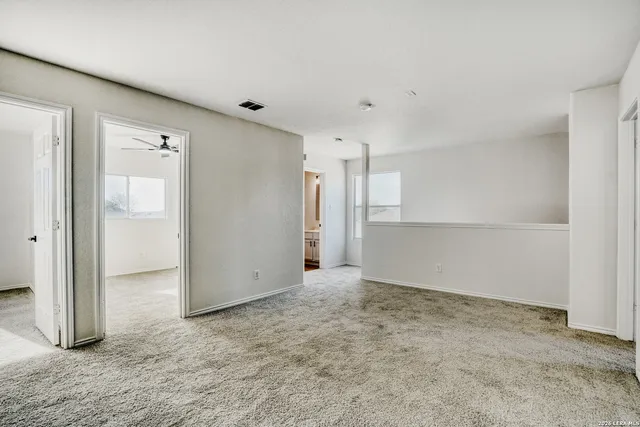 an empty room with a cabinet and mirrors