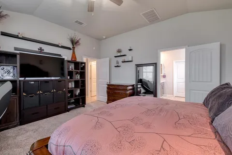 a spacious bedroom with a bed and a chandelier